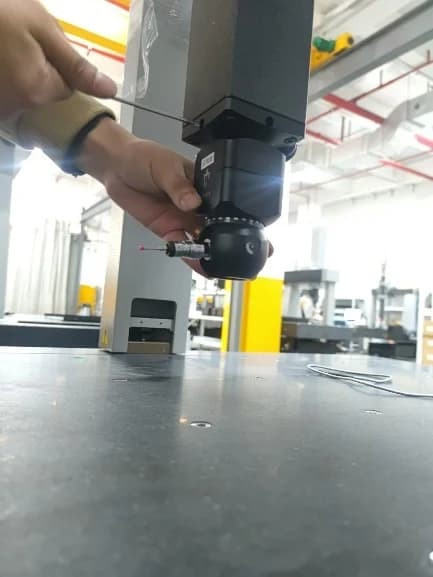 Installation guide photograph showing a probe-head assembly being fitted to a CMM